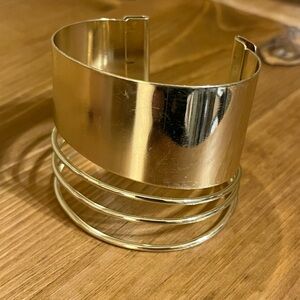 Gold tone cuff with a slanted band and  3 gold wire bands open back size 7”